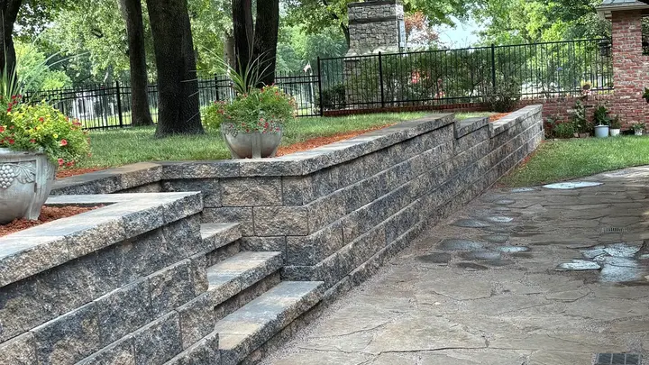 Terraced retaining wall with built-in steps beside a flagstone patio