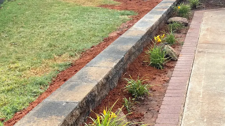 Low garden retaining wall with a new planting bed along a walkway